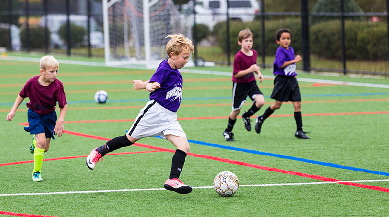 Barn som spelar fotboll utomhus