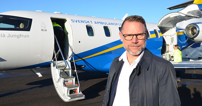 Andreas Svahn bredvid ett ambulansflygplan