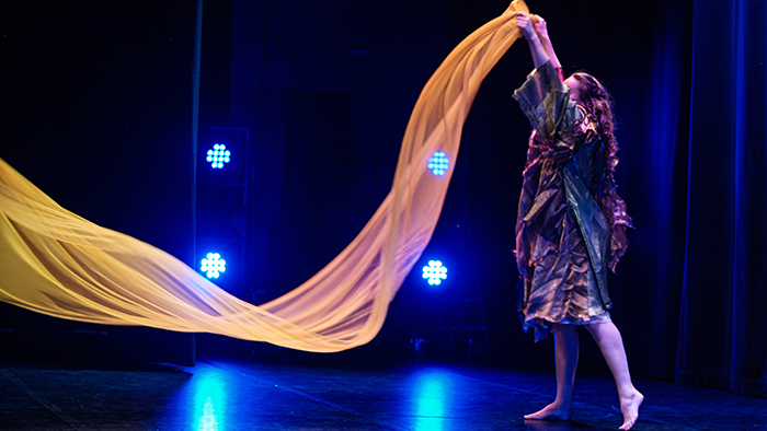 Dansframträdande med skynke på scen. 