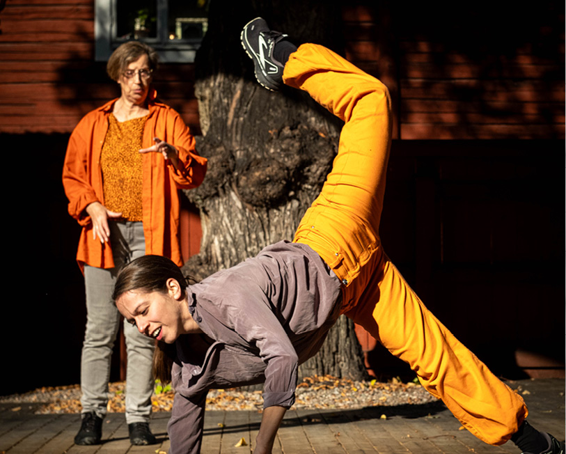 dansare sträcker upp ett ben, bakom står berättaren